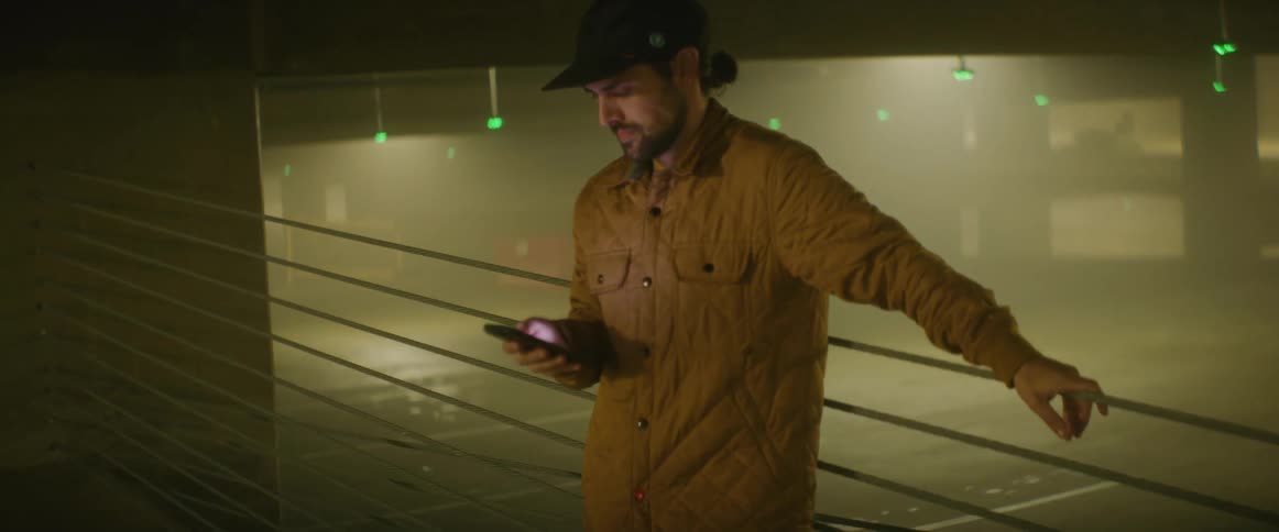 A man flips through his phone inside