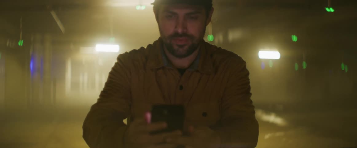 A man is checking his phone at night