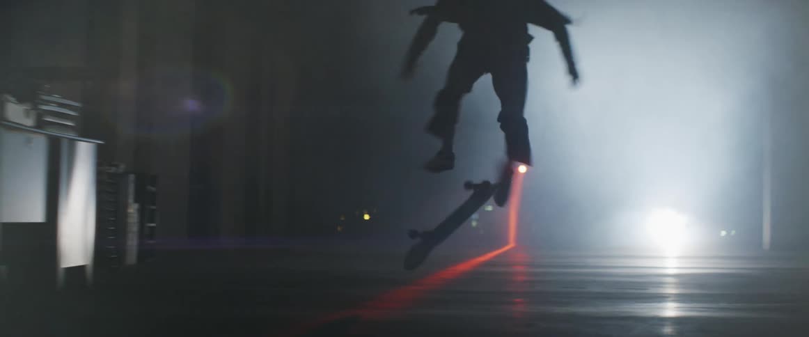A man laughs after attempting a jump on a skateboard and falling