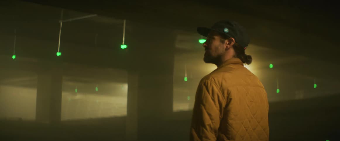 Man walks through dim parking garage