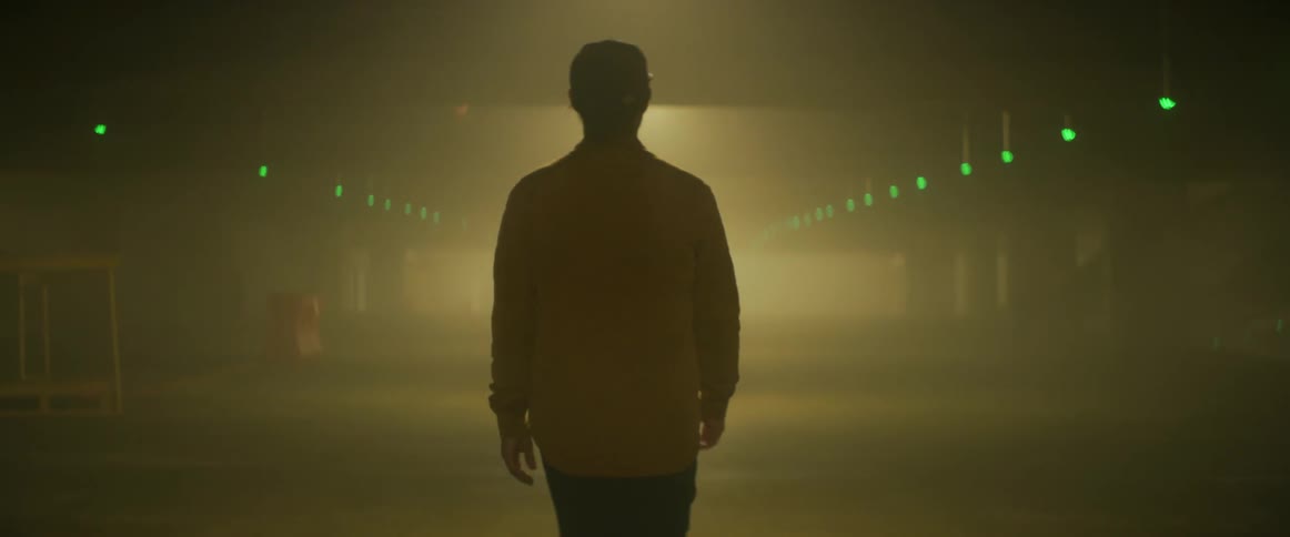 A man walks through a smoke filled parking garage