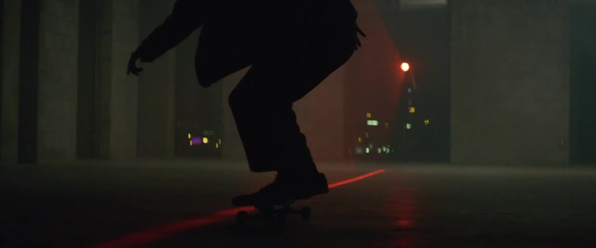Skateboarder makes jump while riding board near laser line