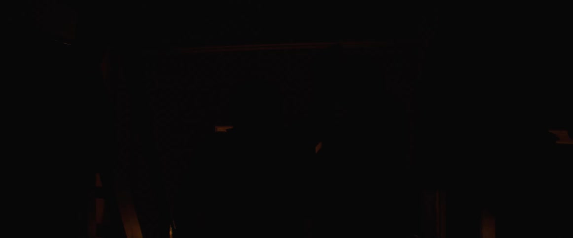 Older couple dances in dark room near staircase leading to rotating beacon