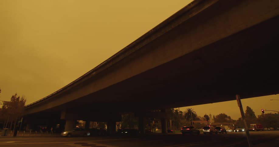 Big road under a bridge with light car traffic during sunset