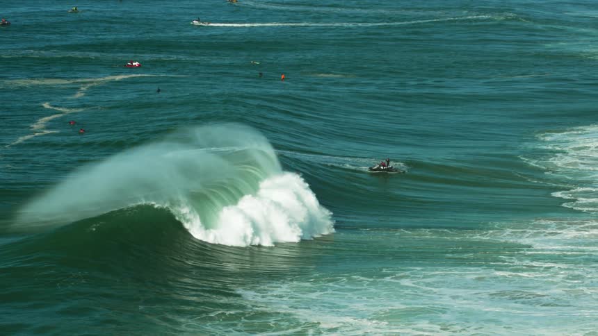 Surfers try to catch a ride on large waves