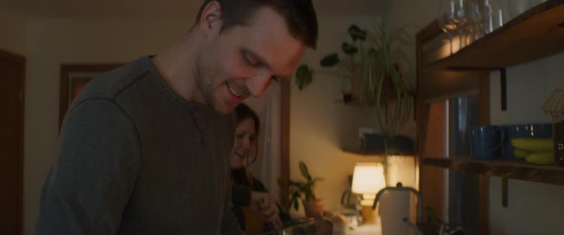 A man cuts an apple in a home kitchen