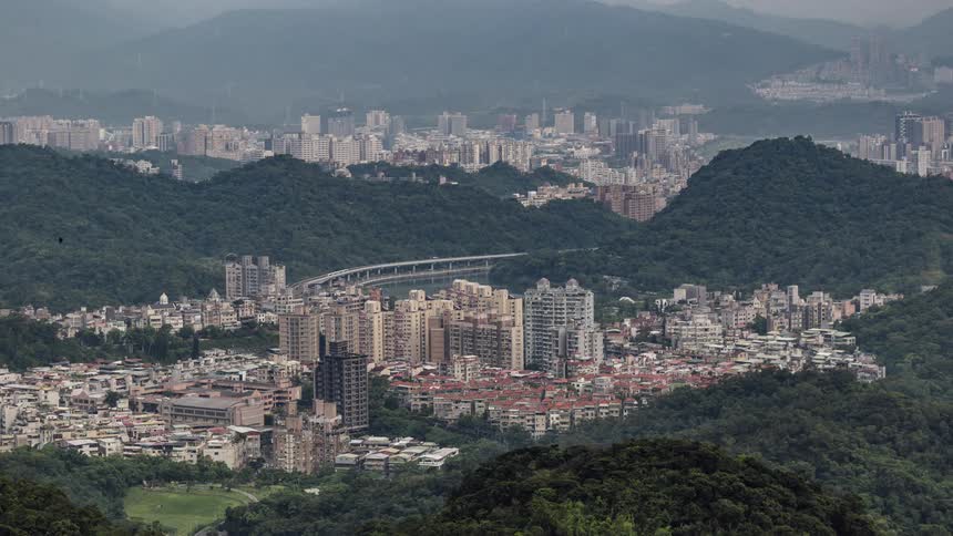 A dense downtown city is nestled between tall hills