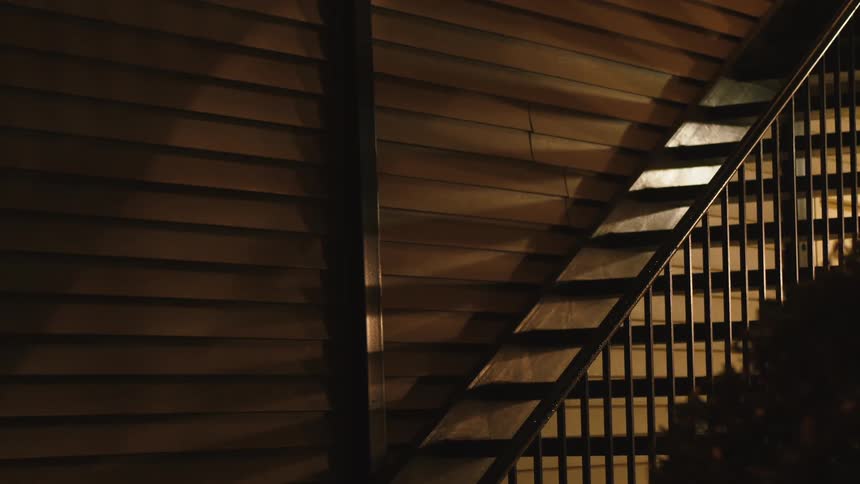 A staircase follows the slant of the walls in a log cabin