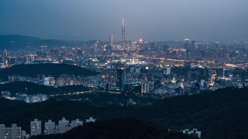 A city lights up as day turns to night