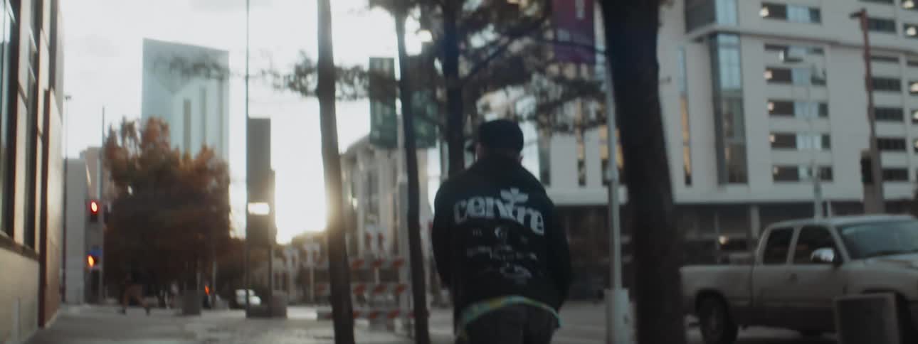Young man rides a skateboard on the city streets at morning