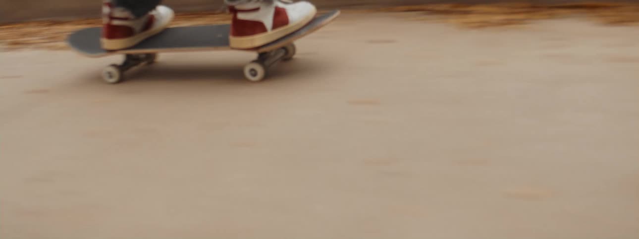 A teenage boy jumping over concrete on a skateboard in a city