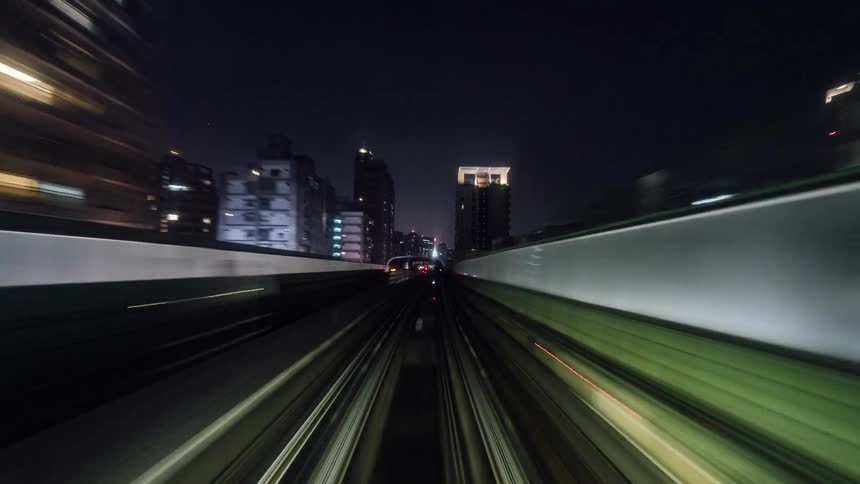 Train tracks lead through city at night