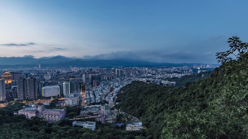 A view of the sun setting over a city into night