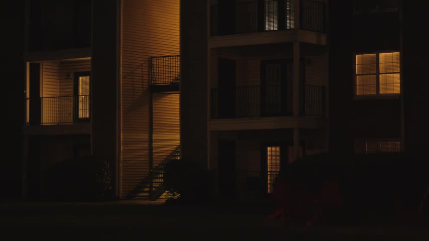 An apartment building is displayed at night