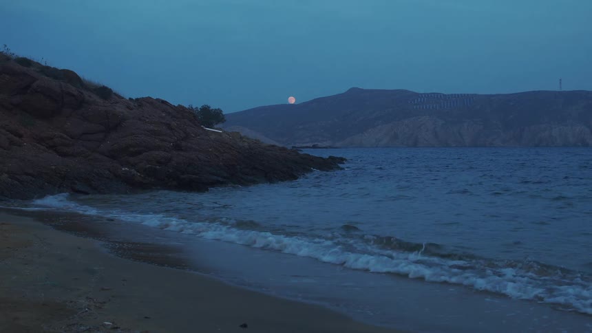 Ocean waves are moving towards the coast at dusk