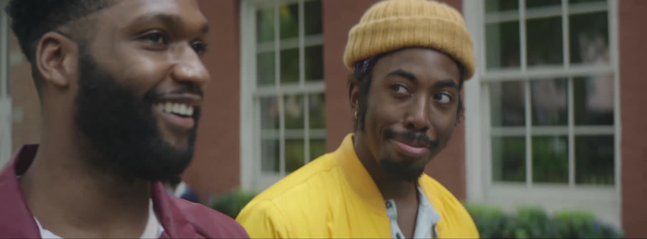Two friends are walking in a neighborhood together