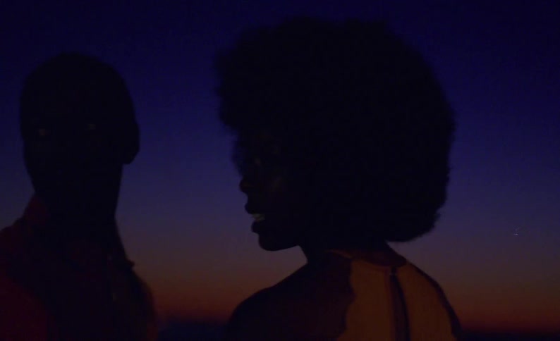 A man and woman turn their heads and look back when startled by a flash of light