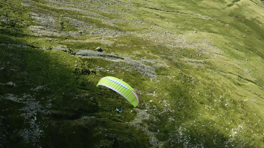 A person is paragliding over the hill