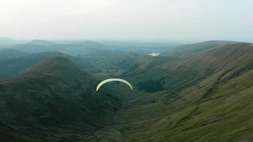 A person parasails over a valley