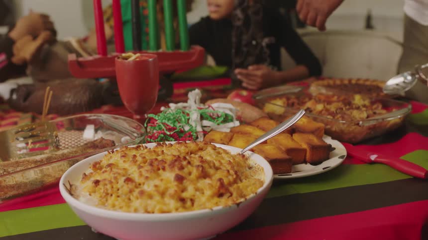 A family celebrate kwanzaa with a meal