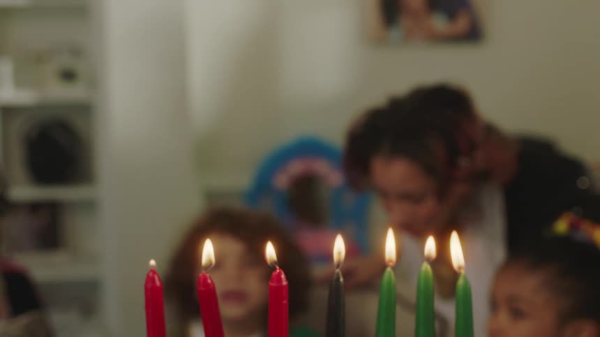A family sits at table with lit candles