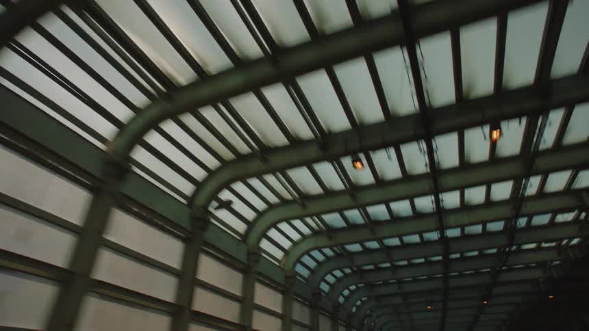 A large traffic sign near downtown sits just outside a tunnel with a glass ceiling