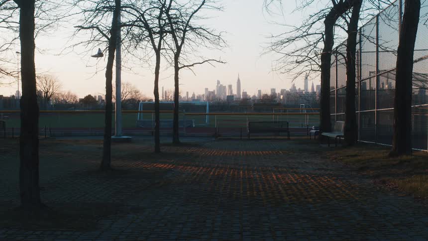 Soccer fields and a tennis court sit in a park across from downtown