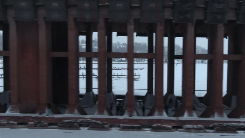 Support columns of a bridge over a frozen lake at winter