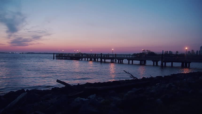 A long pier on the coast at sunset