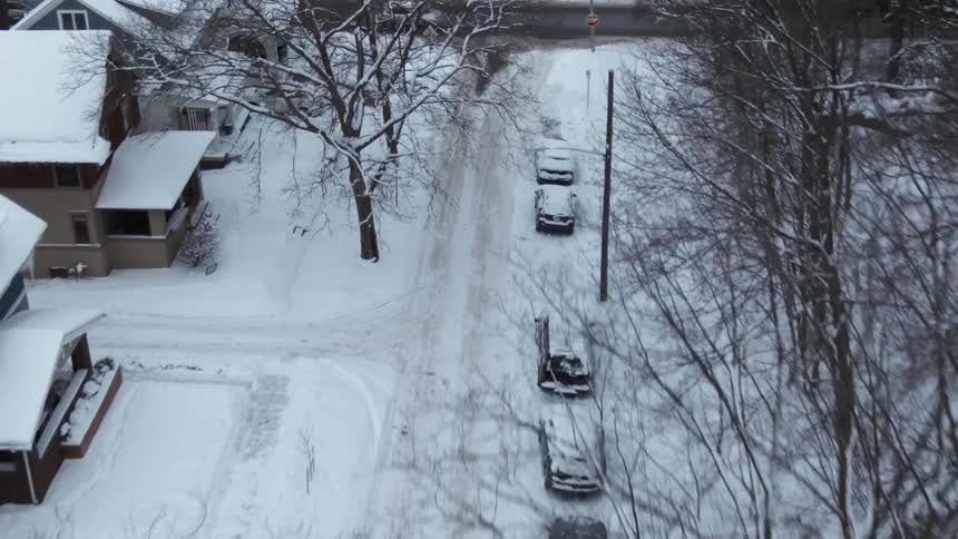 Aerial view of a snow covered neighborhood and traffic on the street