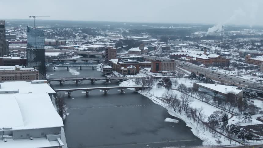 Aerial view of a river flowing through a small town covered in snow at winter