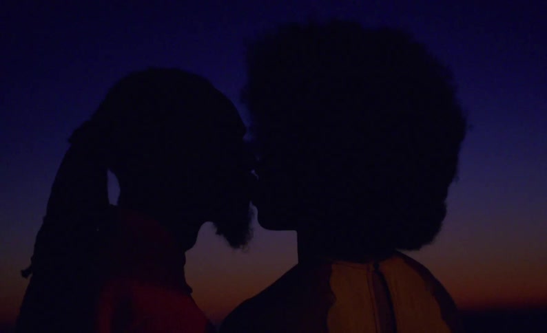 Silhouette of a couple tenderly kissing in the mouth outdoors at evening