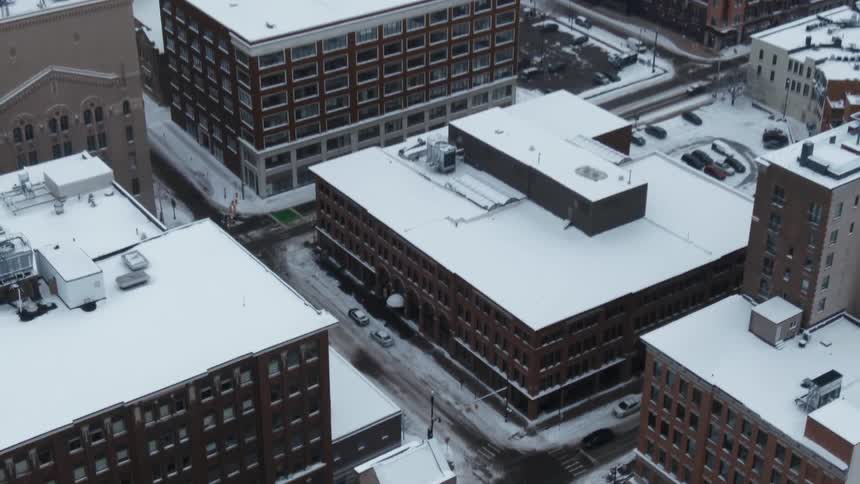 Top down aerial view of streets and buildings of a city completely covered in snow