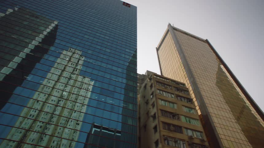 Footage of the facade of tall skyscrapers on the city skyline seen from a moving vehicle