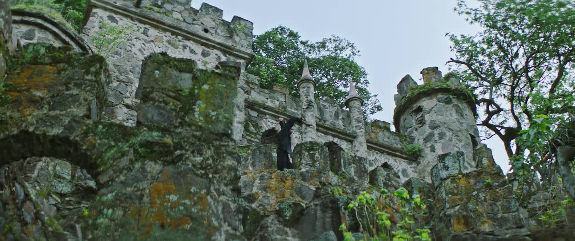 A man dancing outdoors in front of a castle