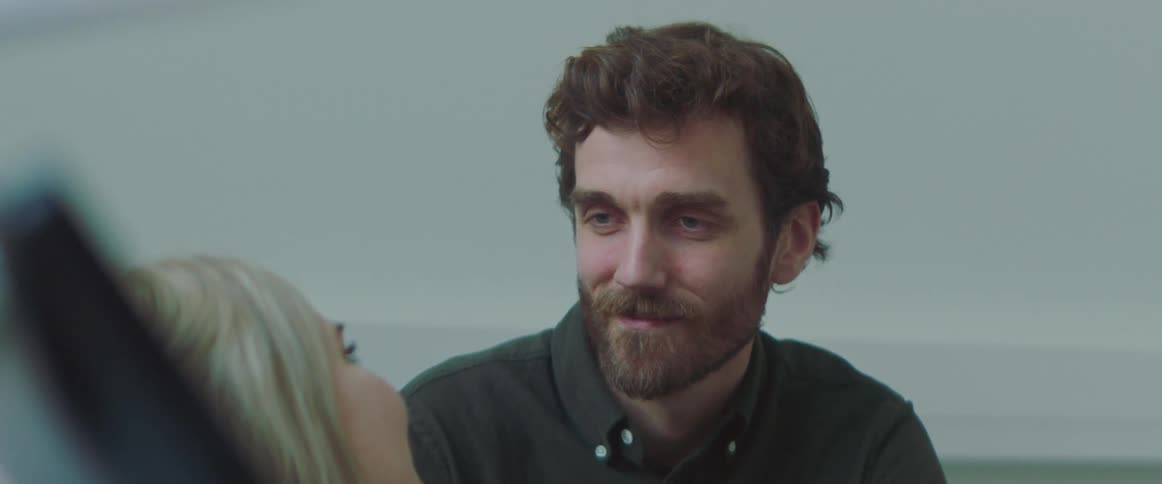 A man is sitting and smiling at a woman