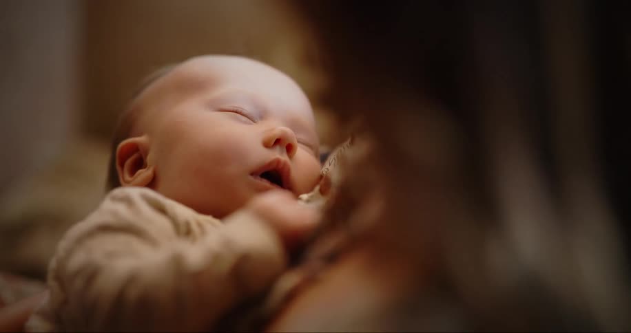 Mother holds sleeping baby against her chest