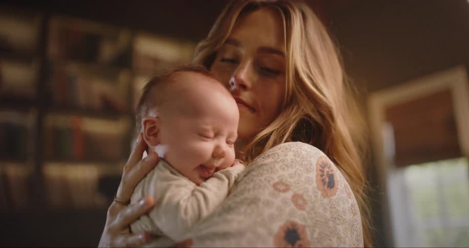 New mom cuddles baby while rocking