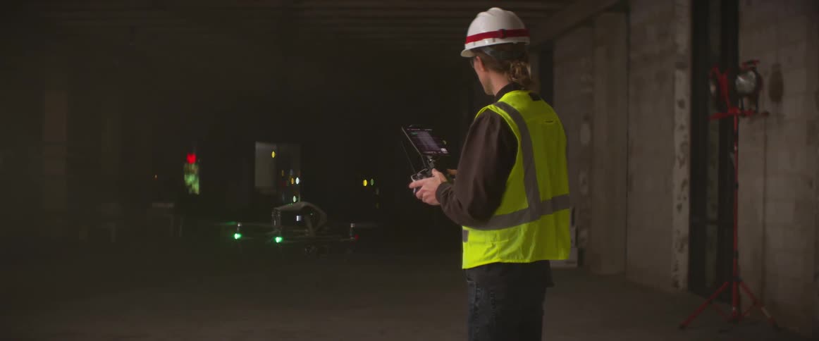Laborer controls drone with a controller