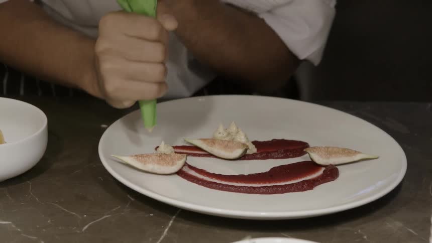 A chef is preparing a plate of food