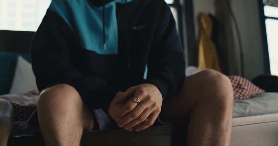 Man sitting on bed removes prosthetic sock