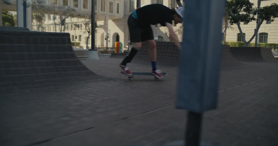 A teenager rides his skateboard over stairs and does stunts in a park