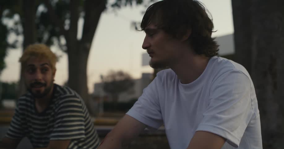 Two guys sitting around outside talking