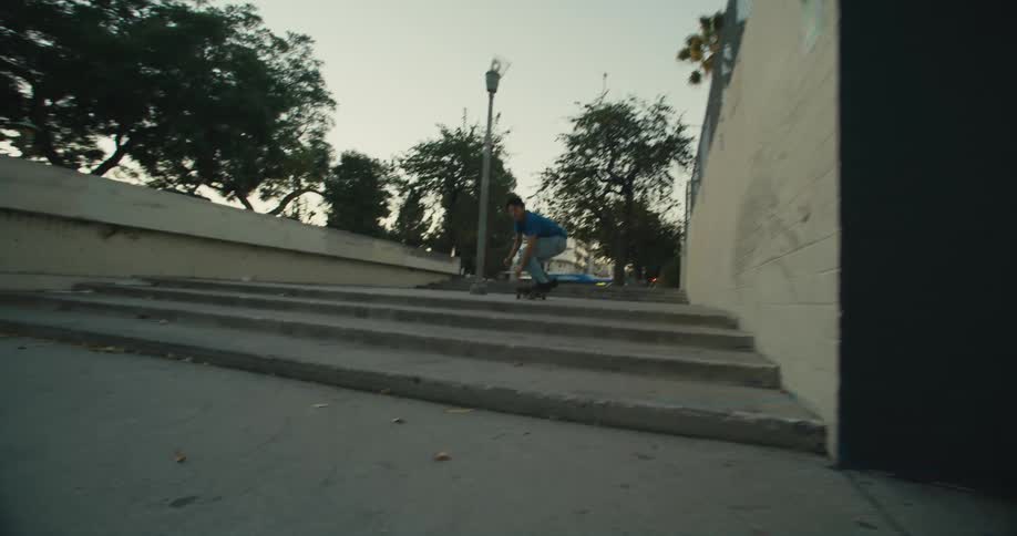 A skateboarder jumps down two levels of concrete stairs