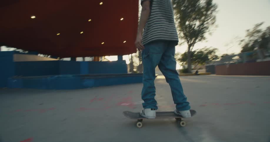 A young man does a skateboard flip in a skate park