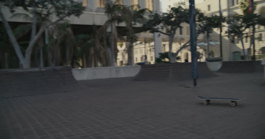 A man with a prosthetic leg performs a jump trick on a skateboard down some stairs but does not stick the landing