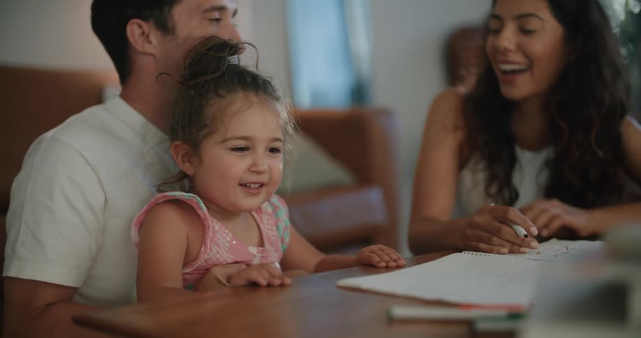 Family sits at coffee table drawing