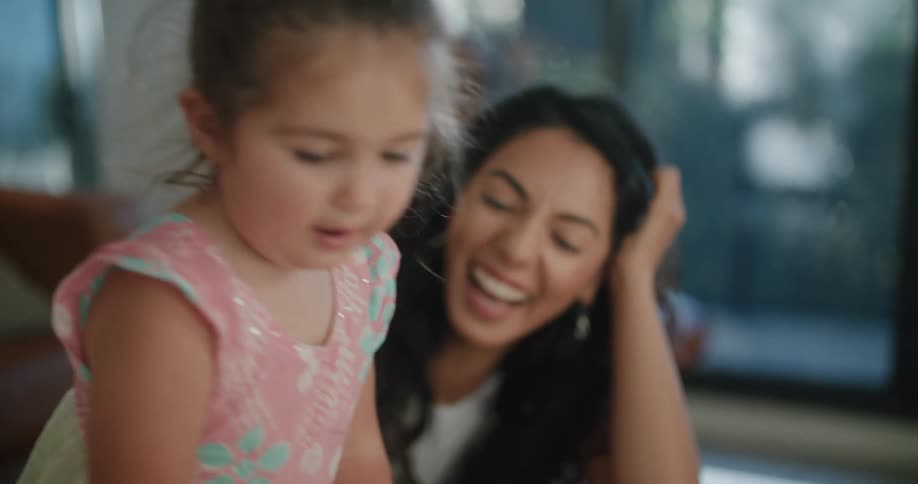 A toddler girl takes a marker from her dad and her mother laughs