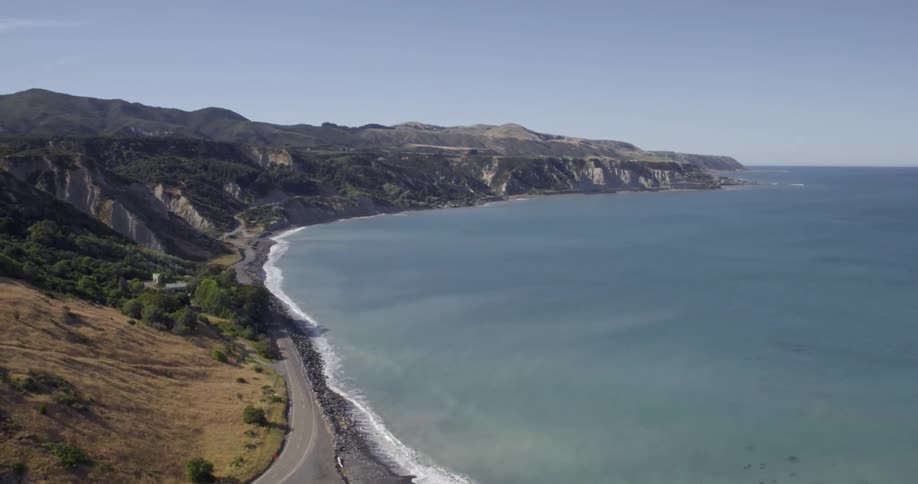A mountain ridge meets a body of water at the shore
