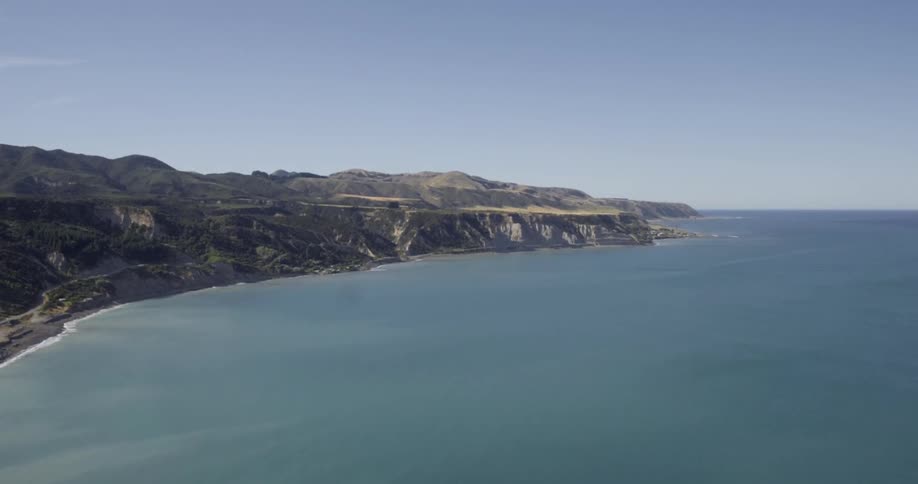 A row of cliffs are lined by an ocean